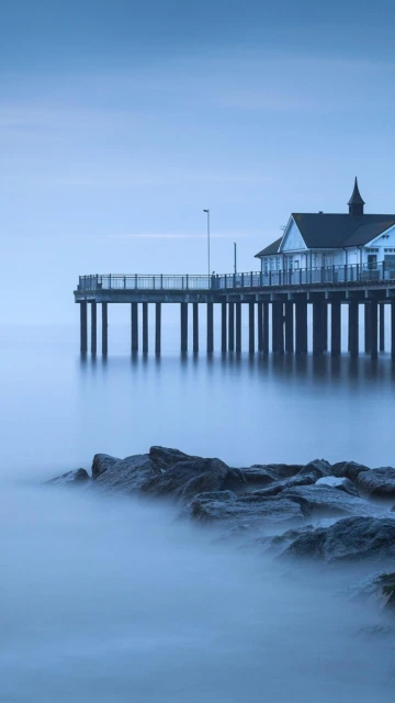 Pier Over Calm Water With Rocks
