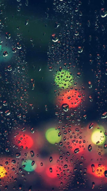 Raindrops on Glass With Colorful Bokeh Lights