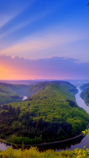 River Winding Through Green Hills at Sunset