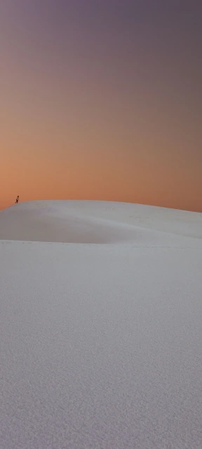 Person on White Dune at Sunset